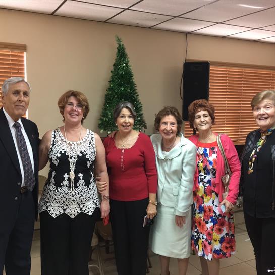 Friends pose together joyfully in a decorated room with a holiday spirit.
