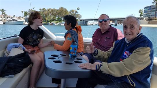 Friends relax and chat on a boat, enjoying good weather and each other's company on the bay.