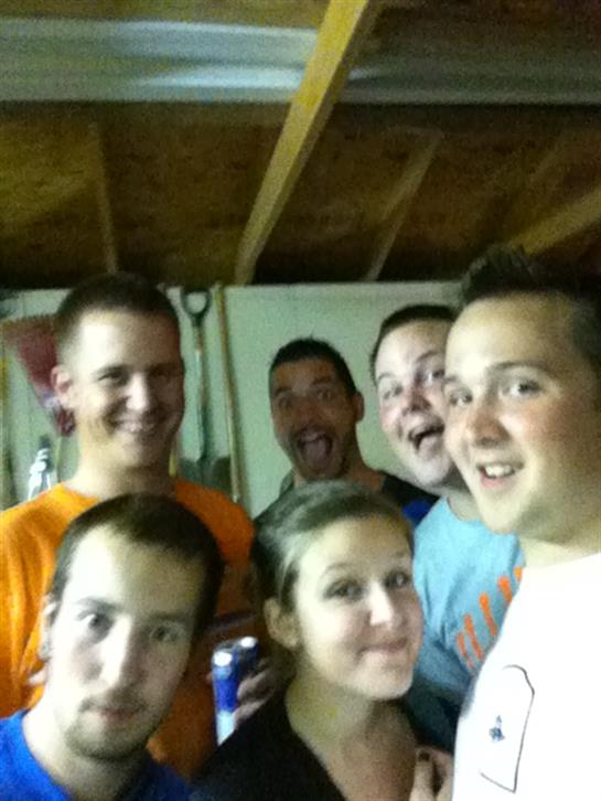 Friends are joyfully posing for a group picture while enjoying their time together indoors.