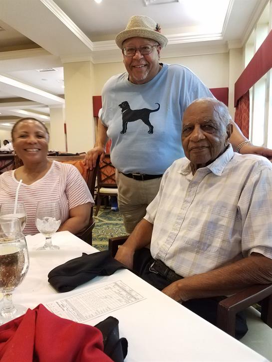 Two seniors and a friend share laughter and conversation during lunch at a restaurant.