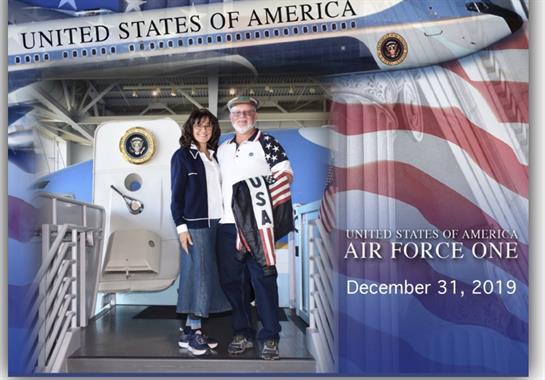 Couple stands together at the entrance of Air Force One, showcasing patriotism on New Year's Eve.