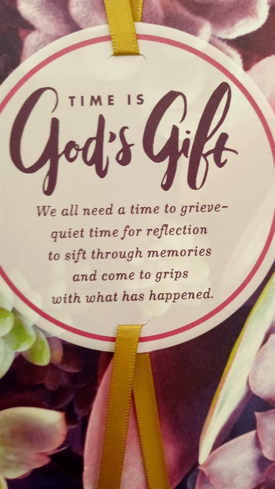 A decorative sign conveys thoughts on grief, encouraging quiet reflection and memory sifting.