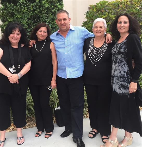 Friends gather together outside, smiling and enjoying each other's company on a cheerful day.
