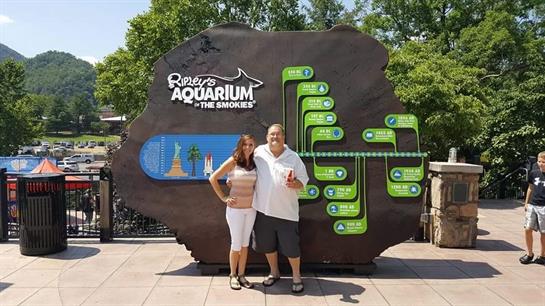 A couple enjoys their day at Ripley's Aquarium, posing by the sign.
