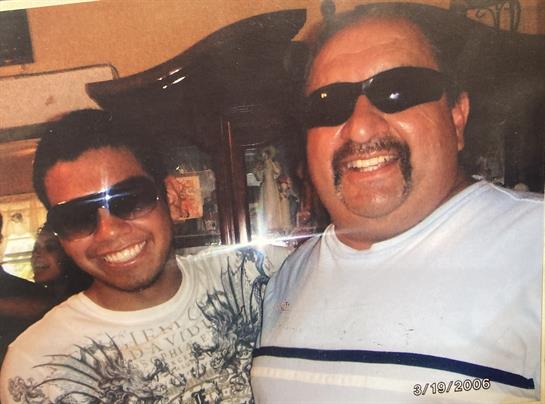 Two friends share a joyful moment, smiling broadly while wearing sunglasses in a cozy atmosphere.