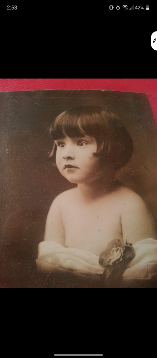 A young girl with short hair poses gently, decorated with delicate flowers.