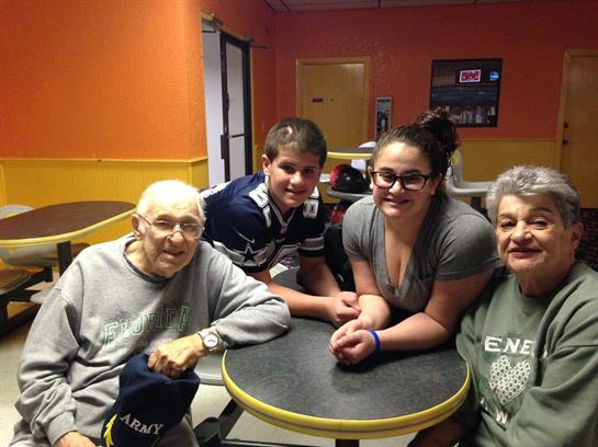 Generations relax and bond at a round table in a restaurant.