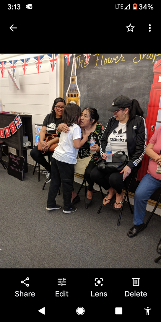 A joyful gathering in a community hall shows children interacting with adults, sharing moments.