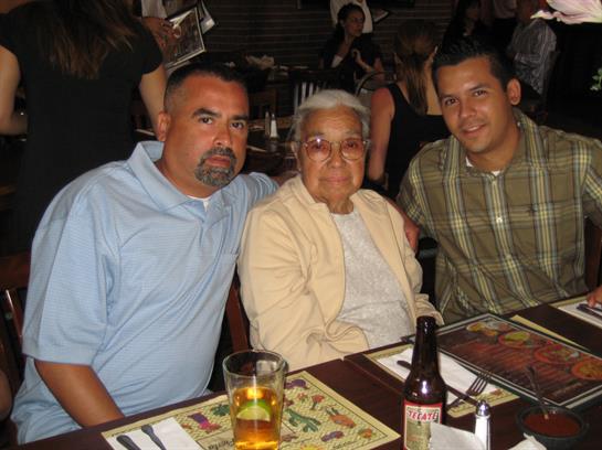 Three family members share a joyful moment at a restaurant, enjoying their time and surroundings.