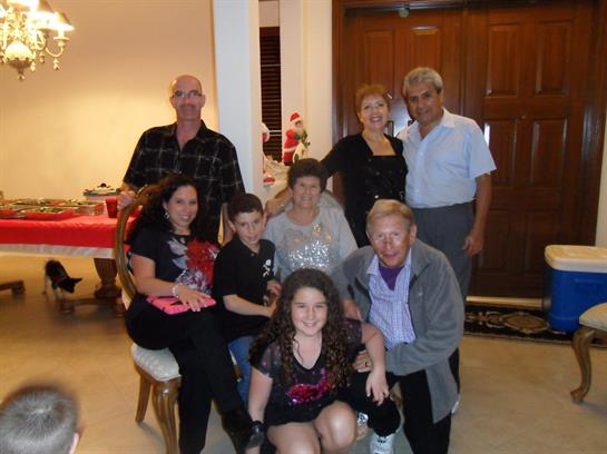 Family members smile and pose together in a warm, inviting living room decorated for the holidays.
