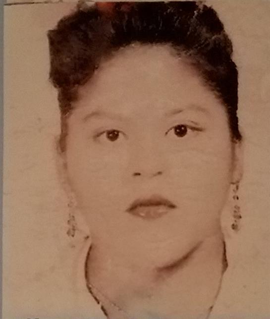 A young woman with curly hair looks directly at the viewer, showing a calm demeanor.