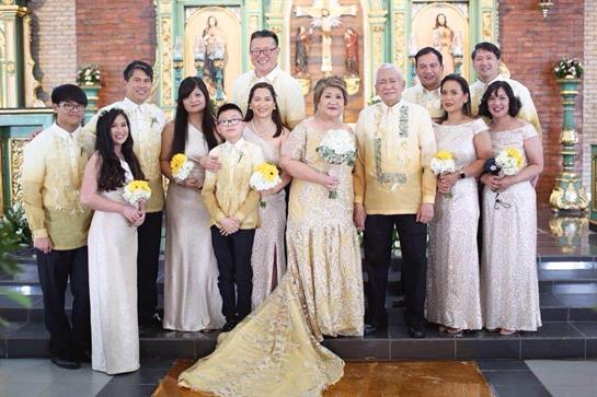 Guests and family members stand together in formal attire, enjoying a wedding ceremony in a church.