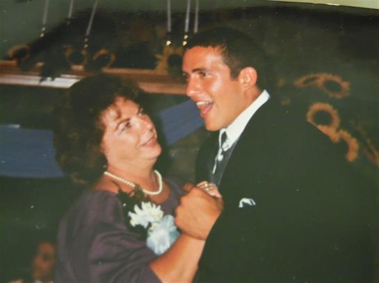 Two individuals share a joyful dance, smiling warmly at each other in a festive setting.