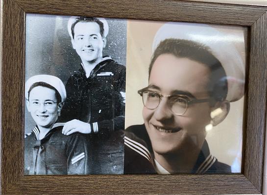 Two sailors pose together, one with glasses, smiling happily in uniform, highlighting camaraderie.