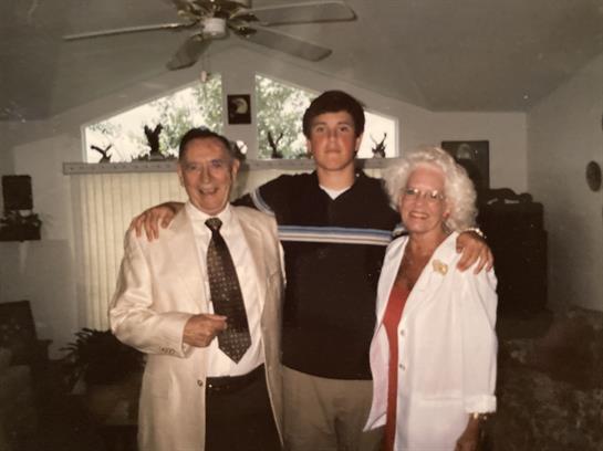 Three family members happily pose together, showcasing their close bonds in a warm setting.
