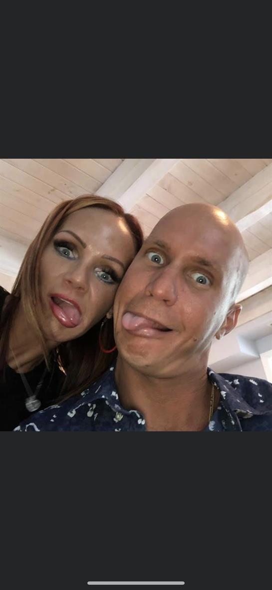 Two people are making funny faces, sharing a lighthearted moment in a lively setting.