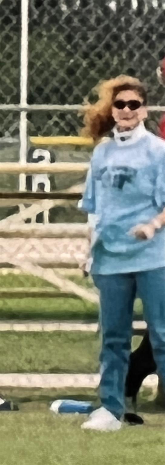 A young person enjoys outdoor play surrounded by nature and wood structures.