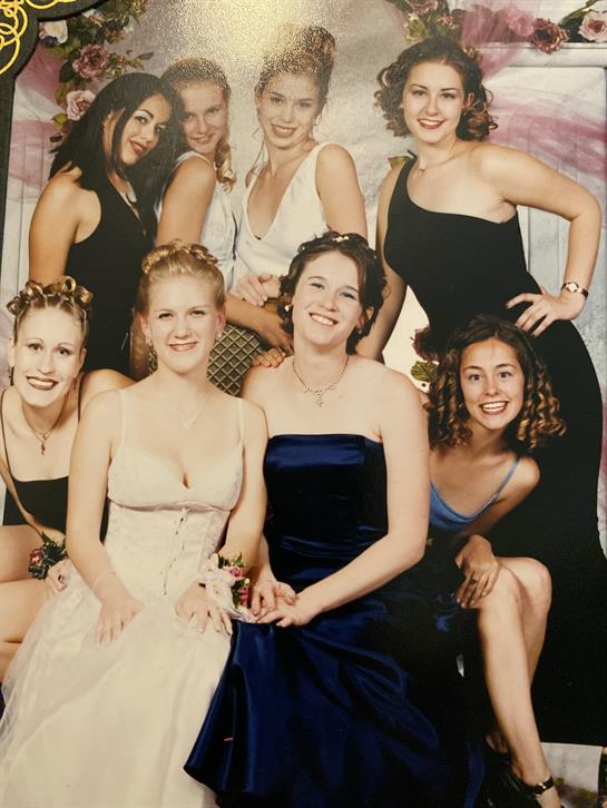 Friends celebrate together, showing off stylish dresses and joyful smiles in a fun vibe.