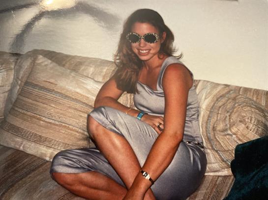 A woman relaxes in a sleek outfit and sunglasses, enjoying her moment of comfort.
