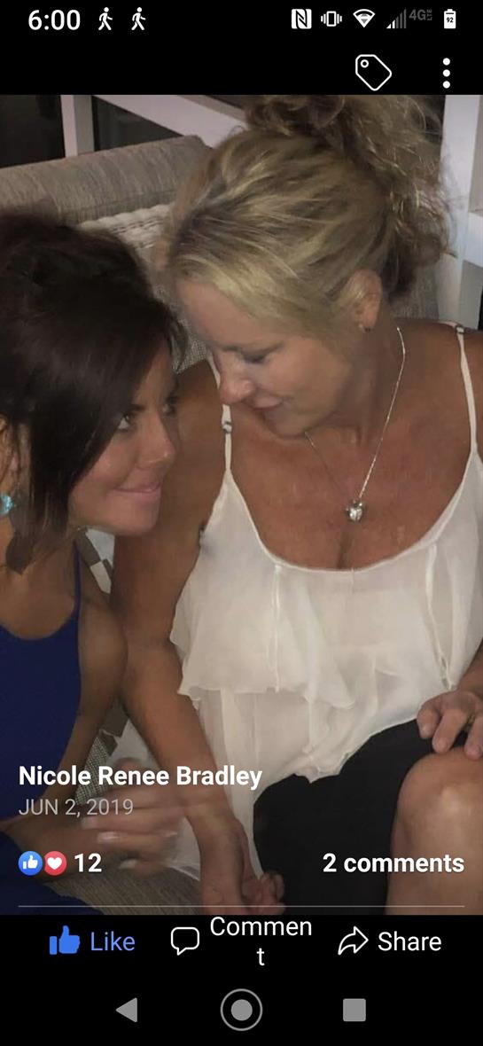 Two friends engage in a warm, friendly conversation while enjoying each other's company at an event.