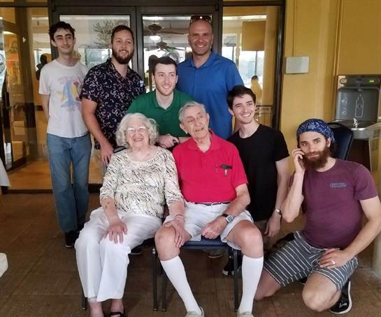Family members pose happily for a photo indoors, showcasing smiles and strong bonds.