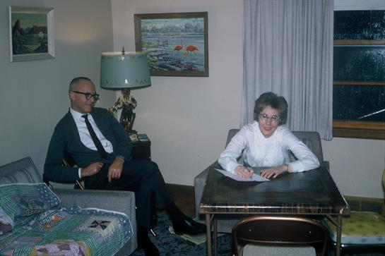A man and woman share a moment in their cozy living room as they engage in conversation.