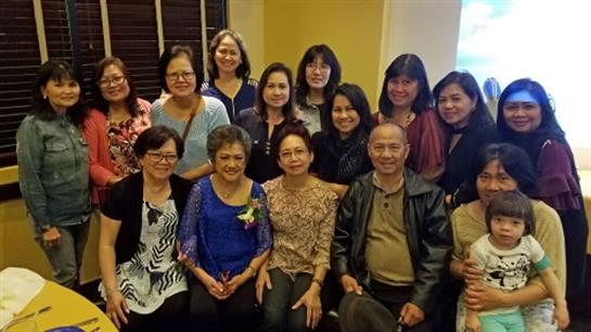 Group of friends and family pose together, smiling and celebrating their bond in a warm setting.