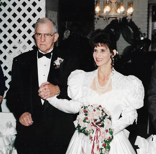 The bride and her escort walk arm in arm, showcasing a joyful celebration of love in formal attire.