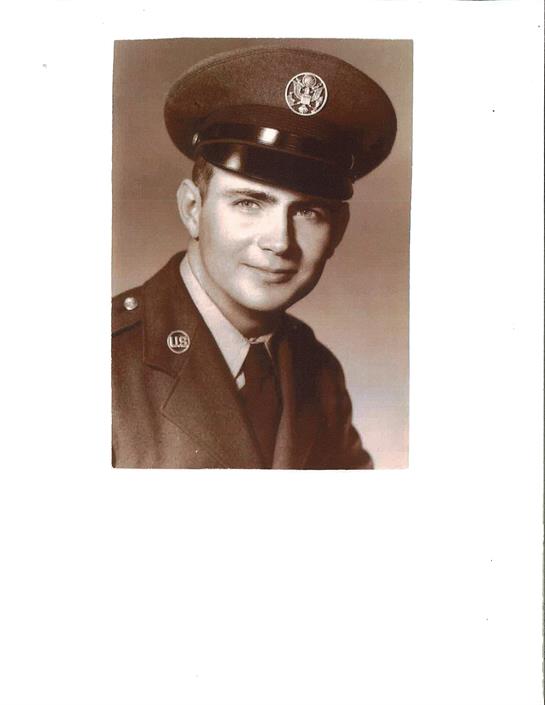 A smiling young man wears a smart military uniform and a cap while posing for a portrait.