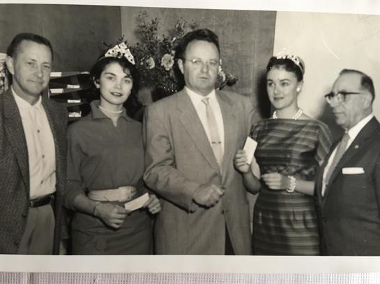 Five elegantly dressed individuals proudly display their awards at a formal event.
