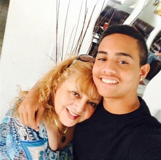 A cheerful mother and son embrace each other while smiling, creating a joyful atmosphere.