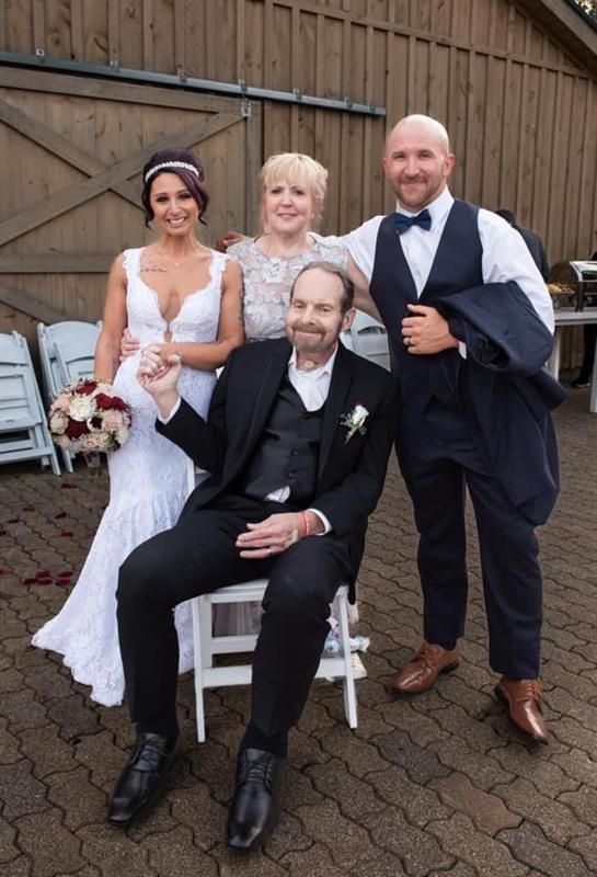 A joyful outdoor wedding with the bride, groom, and family sharing happy moments.