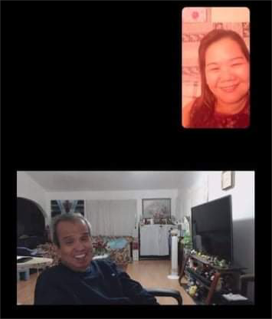 Two friends enjoy a joyful video call in a warmly lit living room during the evening.