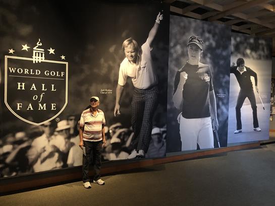 Visitor admires large murals honoring famous golfers and their contributions.