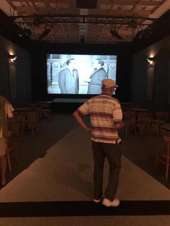 People watch a classic film at an old-fashioned cinema, immersed in a nostalgic atmosphere.