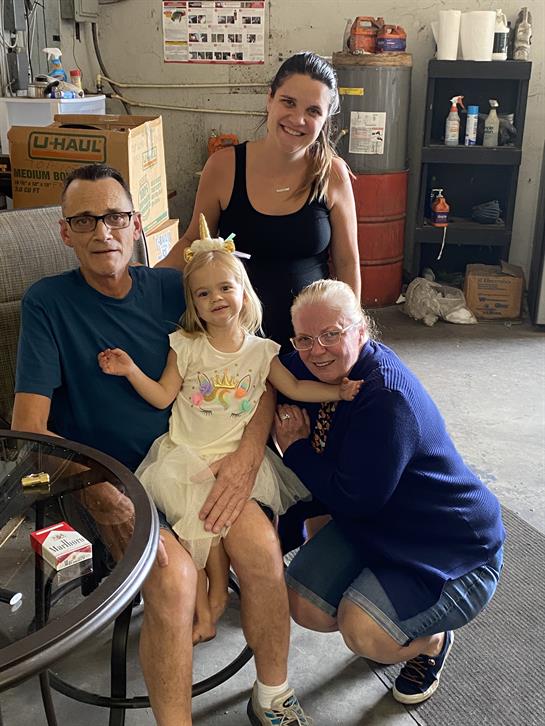 Four family members share a joyful moment in a relaxed indoor space filled with warmth.