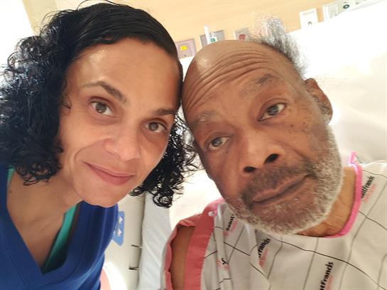 Two people smile closely together in a hospital room, showcasing their bond and connection.