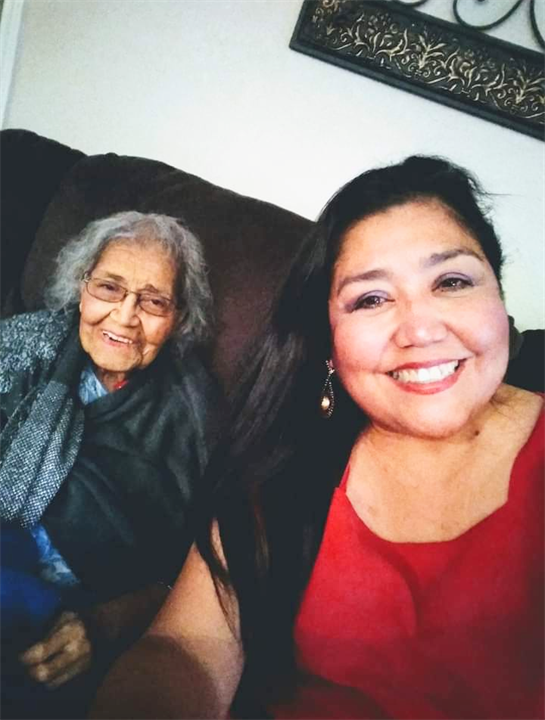 Grandmother and granddaughter enjoy a joyful moment together, sharing smiles on a comfortable sofa.