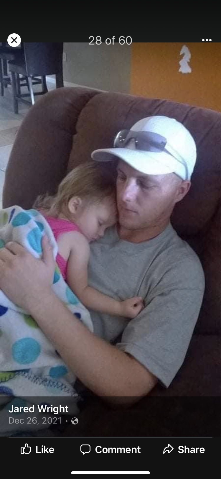A father cradles his sleeping daughter in a relaxed evening atmosphere, showcasing their bond.