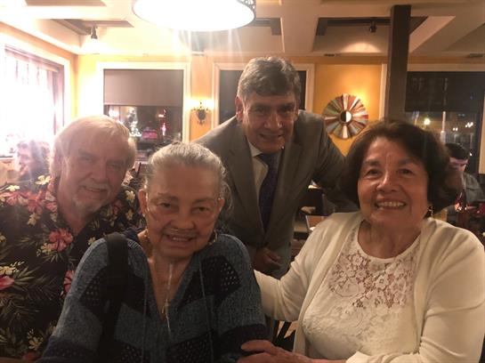 Four friends enjoy a delightful evening at a restaurant, sharing smiles and conversation.