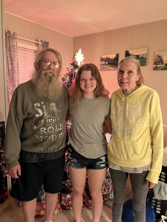 Family members pose together in a warm living room filled with festive decorations.