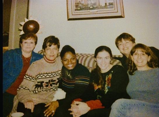 A lively group of friends shares joyful moments together while relaxing on a couch.