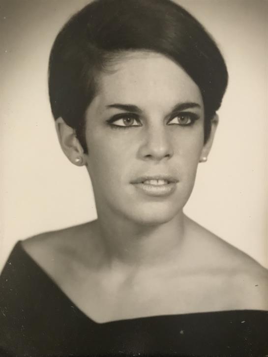 Young woman poses elegantly with a confident expression and vintage hairstyle in black and white.