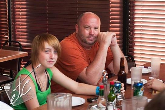Friends relax at a restaurant table, enjoying meals and drinks in a warm, inviting atmosphere.