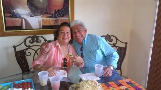 A couple enjoys a meal with drinks in a cozy, charming dining space.