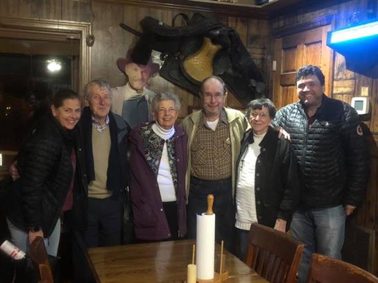 Friends gather in a rustic mountain cabin, sharing laughter and warmth in winter season.