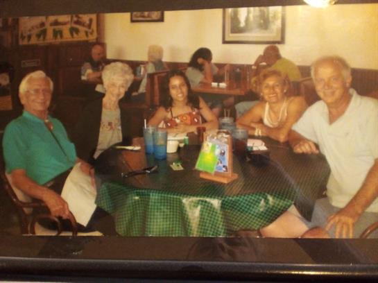 Friends are seated at a round table, engaging in conversation and enjoying refreshments.