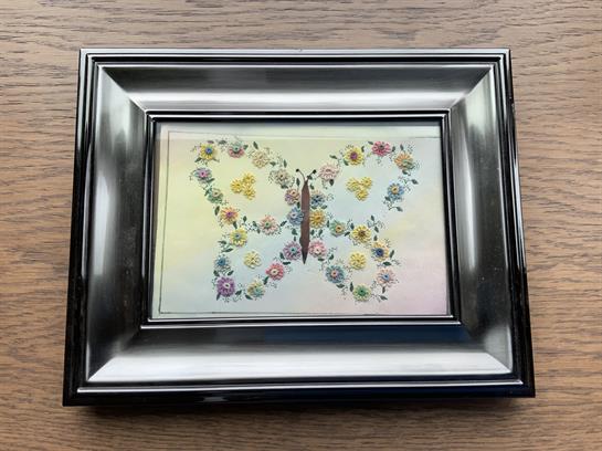 Intricate butterfly design surrounded by colorful flowers in a decorative frame, ideal for any room.