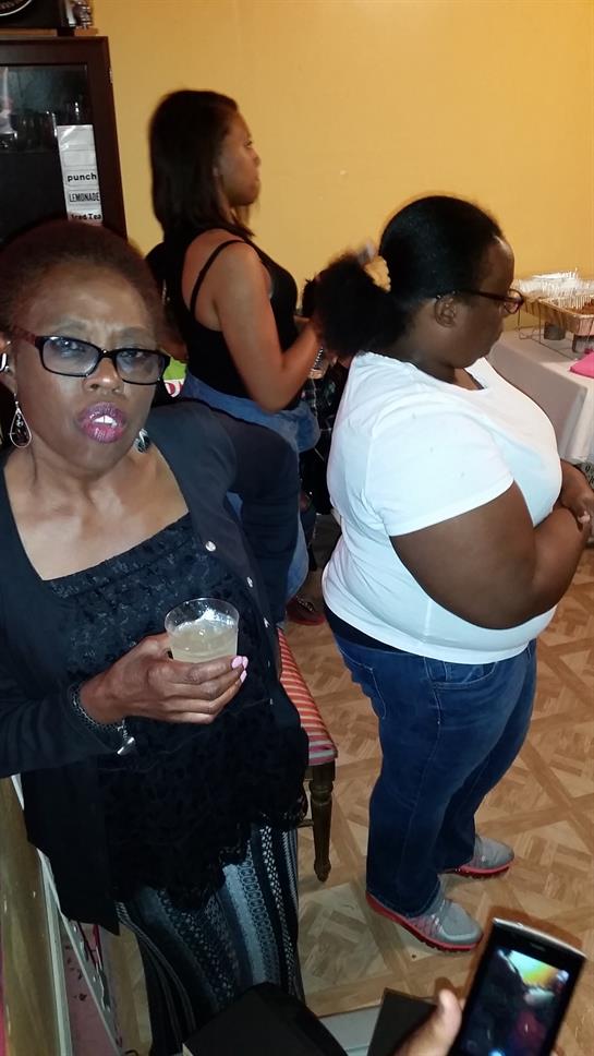 Friends share drinks and engage in lively conversation during a social event at night.