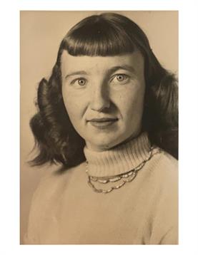 Woman with curly hair wearing a sweater poses with a neutral expression, likely from the 1950s.